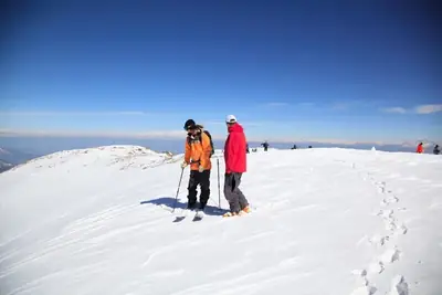 Two skiers on summit enjoying breathtaking Himalayan views