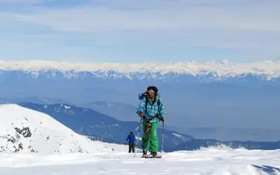 Skier touring with stunning Himalayan range backdrop